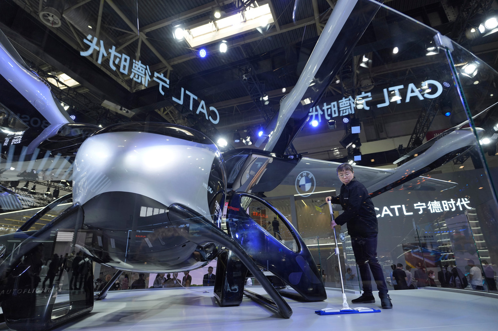 A cleaner works near a flying vehicle prototype from Chinese battery giant CATL during Auto China 2026 in Beijing, Saturday, April 25, 2026. (AP Photo/Ng Han Guan)