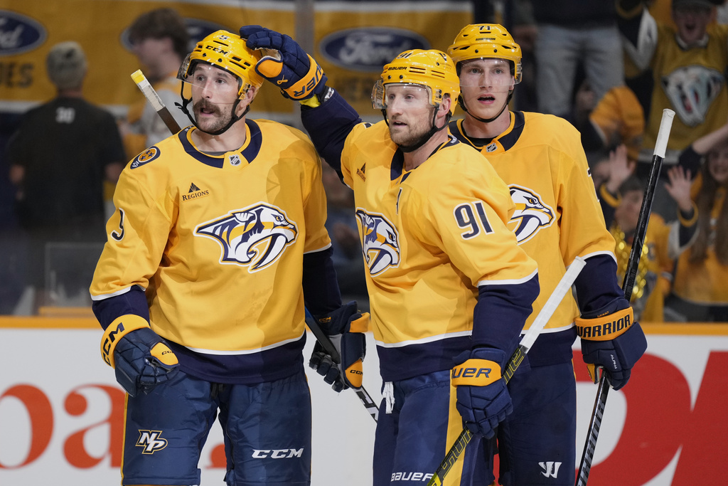 Nashville Predators left wing Filip Forsberg (9) is congratulated after his goal by center Steven Stamkos (91) and right wing Matthew Wood (71) during the second period of an NHL preseason hockey game against the Florida Panthers, Sunday, Sept. 21, 2025, in Nashville, Tenn. (AP Photo/George Walker IV)