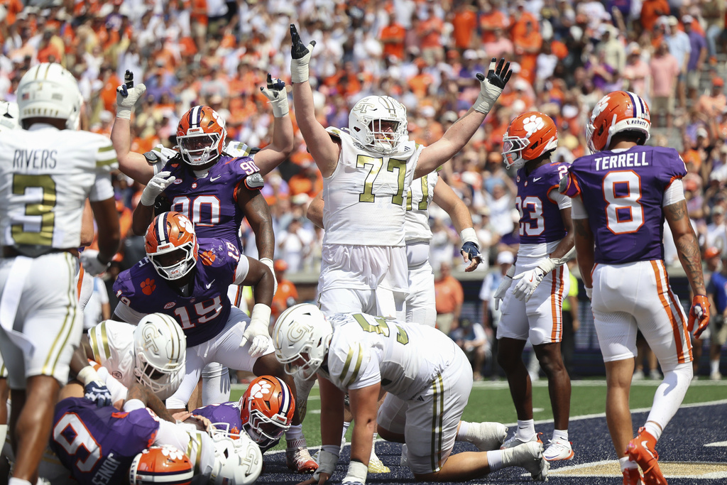 Georgia Tech offensive lineman Keylan Rutledge (77) throws his hands up in celebration after a touchdown during the second half of an NCAA college football game against Clemson, Saturday, Sept. 13, 2025, in Atlanta. (AP Photo/Colin Hubbard)