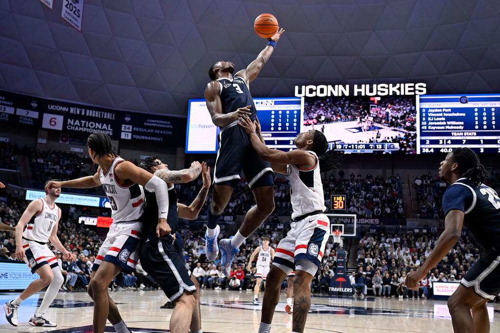 Georgetown center Vincent Iwuchukwu (3) grabs a rebound over UConn guard Silas Demary Jr. in the first half of an NCAA college basketball game, Saturday, Feb. 14, 2026, in Storrs, Conn. (AP Photo/Jessica Hill)
