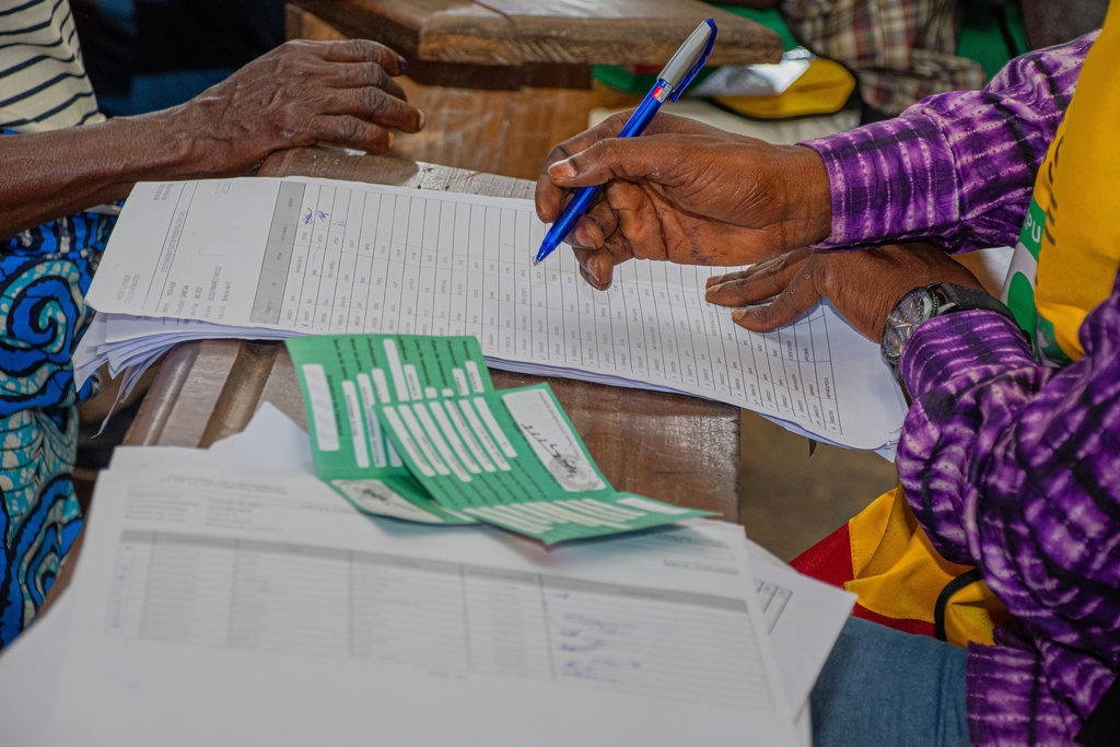 An election official check for the name of a voter in a register at a polling station in Brazzaville, the Republic of Congo, Sunday, March 15, 2026. (AP Photo/Vivace Mambouana)