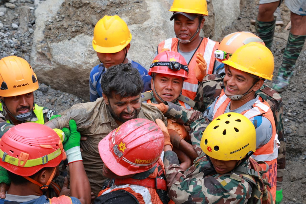 In this photo provided by the Nepal Army, soldiers rescue a worker alive from a tunnel during an ongoing operation at the Trishuli-3A hydropower project in Nepal's Rasuwa district, Friday, Sept. 4, 2026. (Nepal Army via AP)