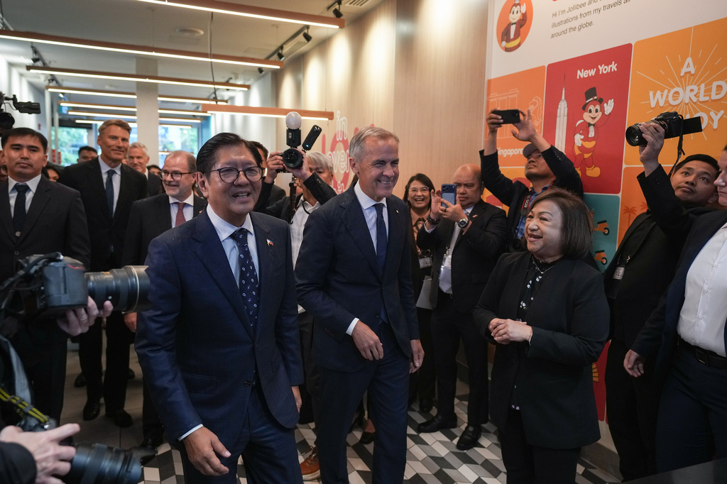 Canada's Prime Minister Mark Carney, center, and Philippines President Ferdinand Marcos Jr., right, arrive for a visit to a Jollibee fast food restaurant, in Vancouver, Thursday, July 2, 2026. (Darryl Dyck/The Canadian Press via AP)