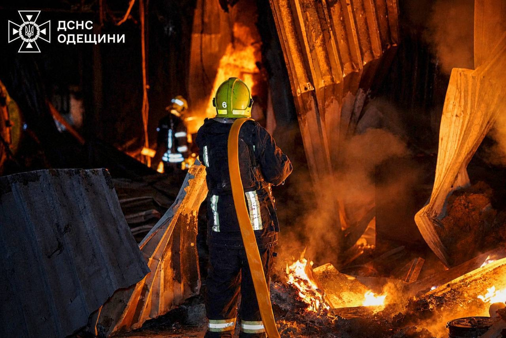 A Ukrainian firefighter puts out a large fire after Russia struck Odesa region overnight on Sunday, May 3, 2026. (Ukrainian Emergency Service via AP)