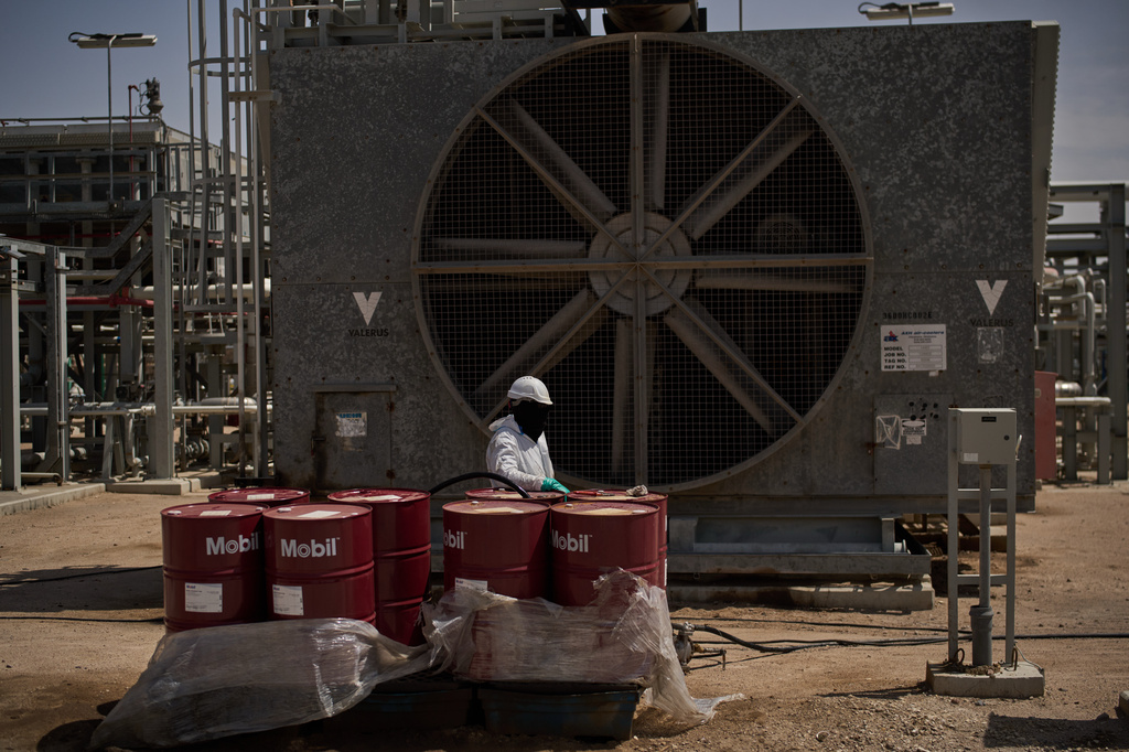 FILE - A worker collects engine oil as he works at a degassing station in Zubair oil field, whose operations have being reduced due to the Mideast war triggered by the U.S. and Israeli attacks on Iran, near Basra, Iraq, Saturday, March 28, 2026. (AP Photo/Leo Correa, File)
