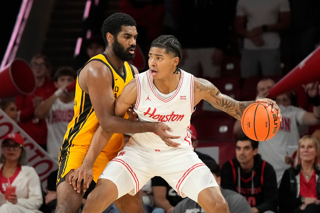 Houston center Chris Cenac Jr., center, controls the ball against Oakland forward Tuburu Naivalurua during the first half of an NCAA college basketball game, Wednesday, Nov. 12, 2025, in Houston. (AP Photo/Karen Warren)
