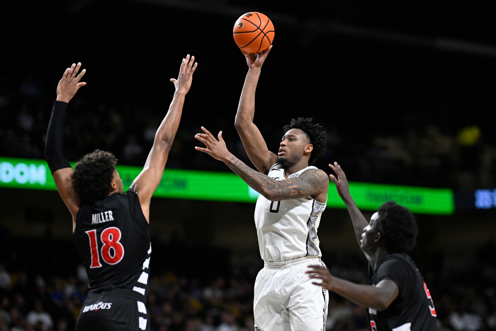 Central Florida center Jeremy Foumena (0) goes up to shoot between Cincinnati forward Baba Miller (18) and center Moustapha Thiam, right, during the second half of an NCAA college basketball game, Sunday, Jan. 11, 2026, in Orlando, Fla. (AP Photo/Phelan M. Ebenhack)