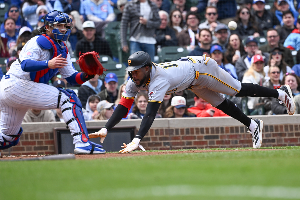 Pittsburgh Pirates' Oneil Cruz (15) scores past Chicago Cubs catcher Miguel Amaya (9) during the third inning of a baseball game, Saturday, April 11, 2026, in Chicago. (AP Photo/Matt Marton)