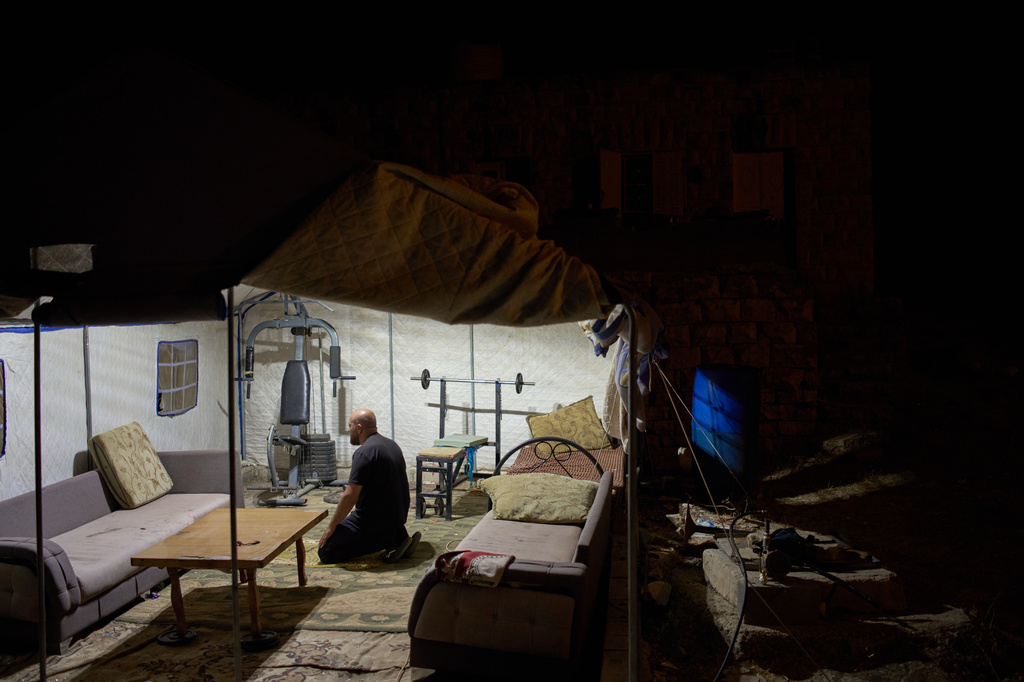 Bilal Dar Khalil prays in a tent as he takes part in a night watch outside his family's house to help prevent Israeli settler attacks in the West Bank town of Sinjil, Monday, July 27, 2026. (AP Photo/Leo Correa)