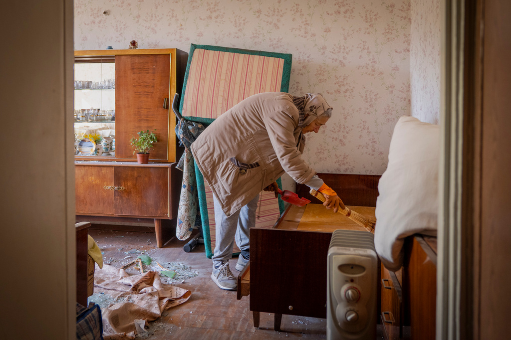 A woman cleans her apartment after a Russian missile exploded near her home in Kyiv, Ukraine, Thursday, Sept. 17, 2026. (AP Photo/Dan Bashakov)