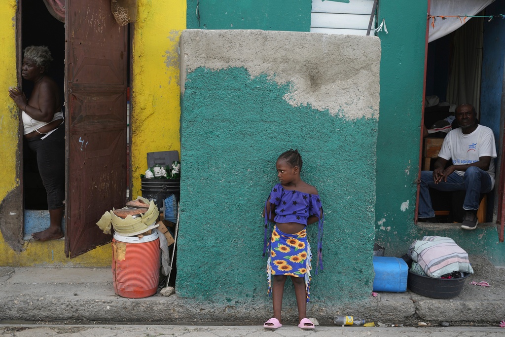 People look out at a street in the Simon-Pele neighborhood of Port-au-Prince, Haiti, Monday, Sept. 22, 2025. (AP Photo/Odelyn Joseph)