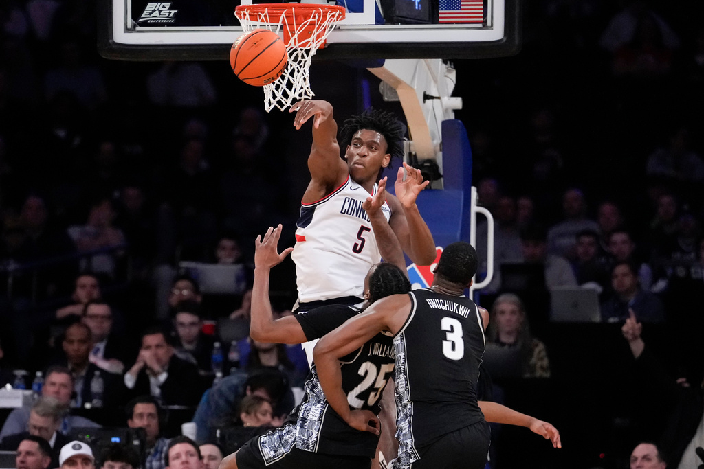 UConn forward Tarris Reed Jr. (5) blocks Georgetown guard Jeremiah Williams (25) during the first half of an NCAA college basketball game in the semifinals of the Big East tournament, Friday, March 13, 2026, in New York. (AP Photo/Yuki Iwamura)
