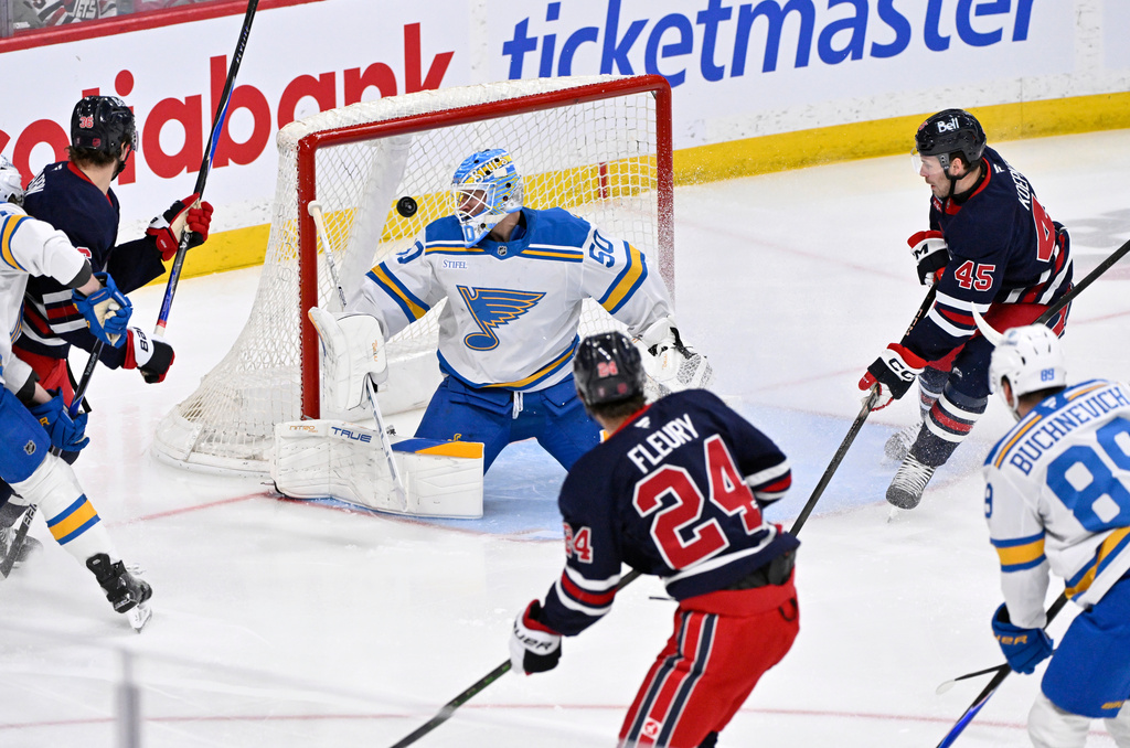 Winnipeg Jets' Haydn Fleury (24) scores against St. Louis Blues' goaltender Jordan Binnington (50) during first-period NHL hockey game action in Winnipeg, Manitoba, Sunday March 15, 2026. (Fred Greenslade/The Canadian Press via AP)