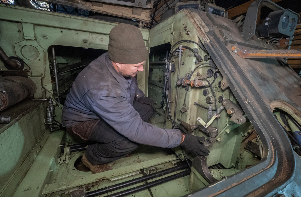 A Ukrainian soldier from repair and recovery battalion of the 57th separate brigade repairs an armoured personnel carrier (APC) outskirts Kharkiv, Ukraine, Monday, Oct. 20, 2025. (AP Photo/Andrii Marienko)