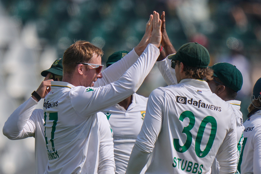 South Africa's Simon Harmer, left, celebrates with teammates after taking the wicket of Pakistan's Imam-ul-Haq during the first day of the second test cricket match between Pakistan and South Africa, at the Rawalpindi Cricket Stadium, in Rawalpindi, Pakistan, Monday, Oct. 20, 2025. (AP Photo/Anjum Naveed)