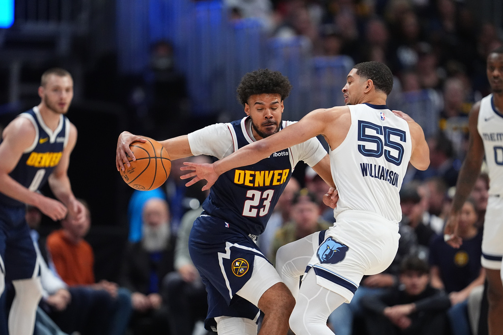 Denver Nuggets forward Cameron Johnson, left, drives to the rim as Memphis Grizzlies guard Lucas Williamson in the first half of an NBA basketball game Wednesday, April 8, 2026, in Denver. (AP Photo/David Zalubowski)