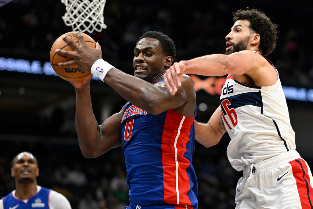 Detroit Pistons center Jalen Duren (0) grabs a rebound against Washington Wizards forward Anthony Gill during the first half of an NBA basketball game, Tuesday, March 17, 2026, in Washington. (AP Photo/John McDonnell)