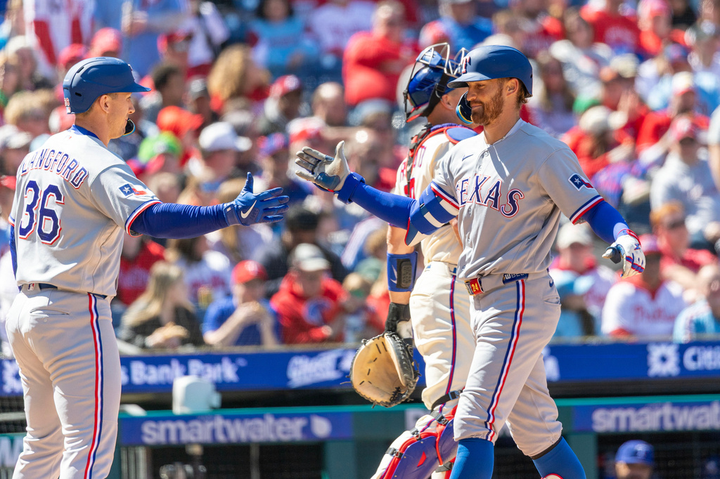Texas Rangers' Brandon Nimmo, right, celebrates his two run homer with Wyatt Langford (36) in the third inning of a baseball game against the Philadelphia Phillies, Sunday, March 29, 2026, in Philadelphia. (AP Photo/Laurence Kesterson)