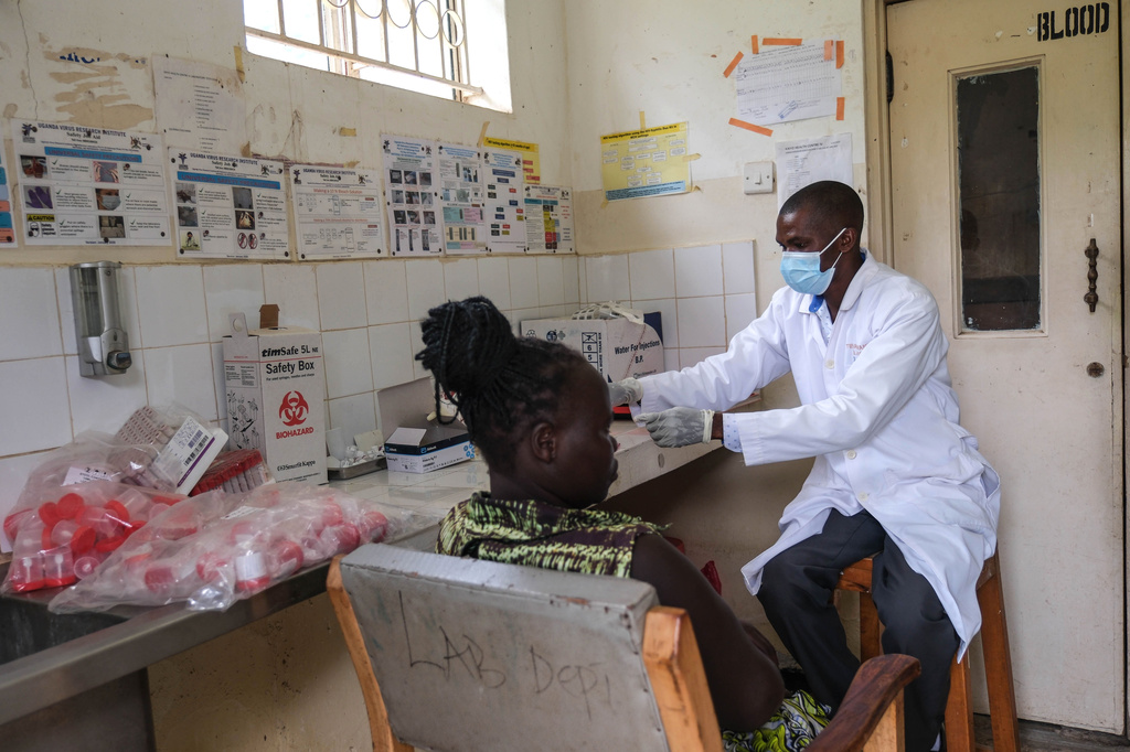A laboratory technician works with a patient at Kikyo Health Centre IV in Kikyo Trading village, Bundibugyo District, Uganda, Wednesday, June 3, 2026. (AP Photo/Hajarah Nalwadda)
