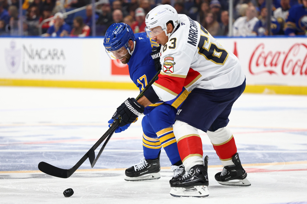 Buffalo Sabres left wing Jason Zucker (17) and Florida Panthers left wing Brad Marchand (63) battle for the puck during the first period of an NHL hockey game, Saturday, Oct. 18, 2025, in Buffalo, N.Y. (AP Photo/Jeffrey T. Barnes)