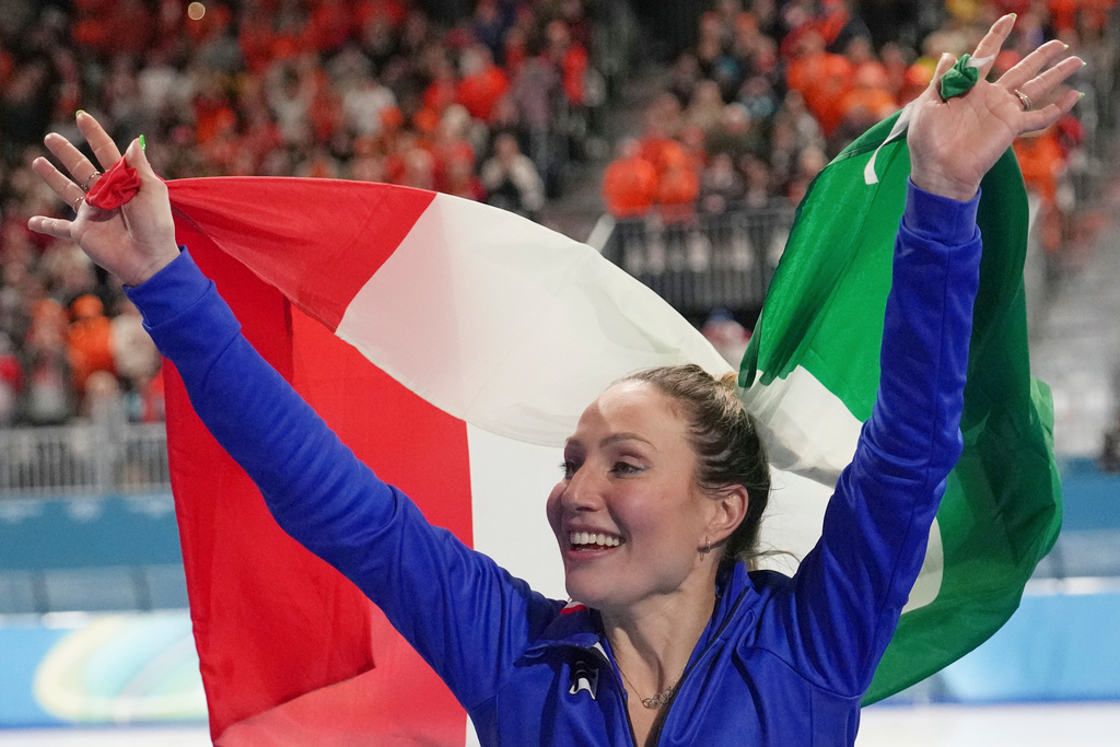Gold medallist Francesca Lollobrigida of Italy celebrates with the Italian flag after the women's 3,000 meters speedskating race at the 2026 Winter Olympics, in Milan, Italy, Saturday, Feb. 7, 2026. (AP Photo/Christophe Ena)