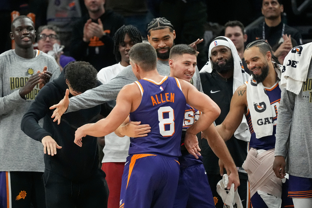 Phoenix Suns guard Grayson Allen (8) gets a hug from Suns guard Collin Gillespie (12) after Allen made his 10th 3-pointer of the basketball game against the New Orleans Pelicans during the second half of an NBA basketball game Monday, Nov. 10, 2025, in Phoenix. (AP Photo/Ross D. Franklin)