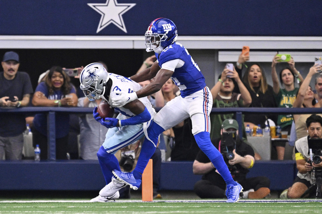 Dallas Cowboys wide receiver George Pickens (3) catches a touchdown pass as New York Giants' Paulson Adebo (21) defends in the second half of an NFL football game Sunday, Sept. 14, 2025, in Arlington, Texas. (AP Photo/Jerome Miron)