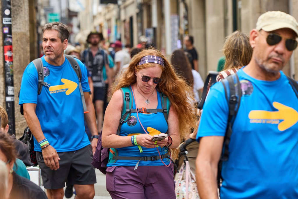 Pilgrims walk in Santiago de Compostela downtown, northwestern Spain, Thursday, Aug. 21, 2025. (AP Photo/Lalo Villar)