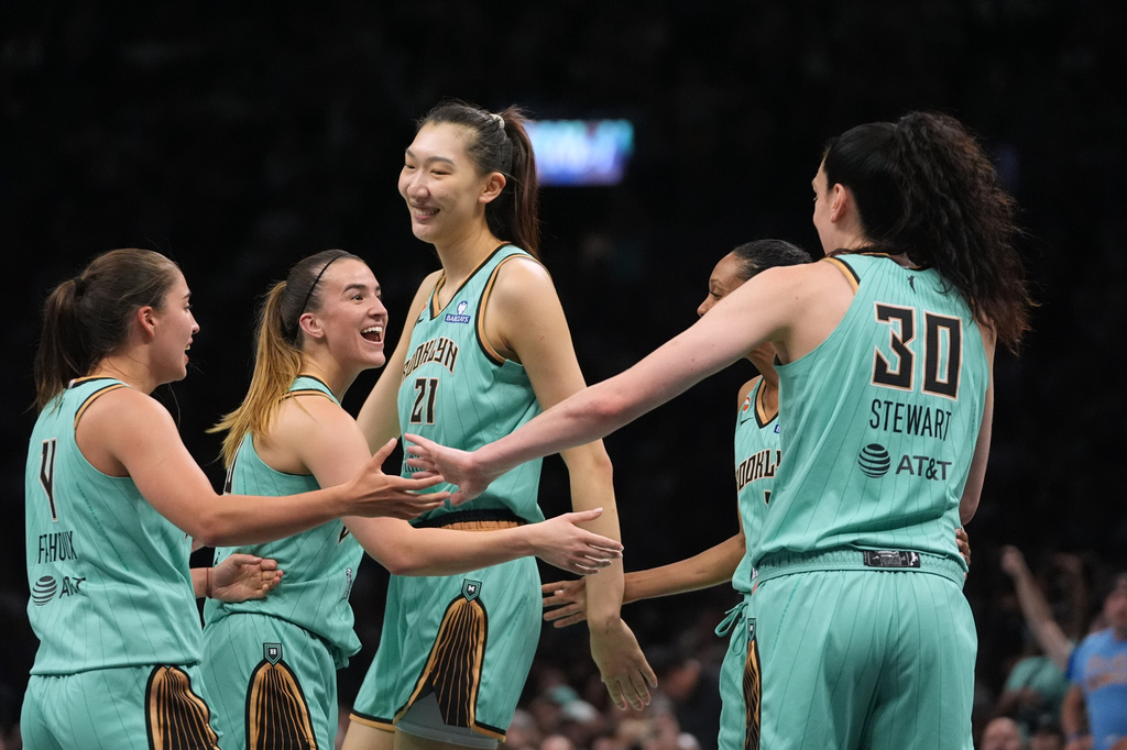 New York Liberty's Han Xu (21) celebrates with teammates Sabrina Ionescu, Breanna Stewart (30) and Marine Fauthoux (4) after scoring during the second half of a WNBA basketball game against the Chicago Sky Wednesday, July 22, 2026, in New York. (AP Photo/Frank Franklin II)
