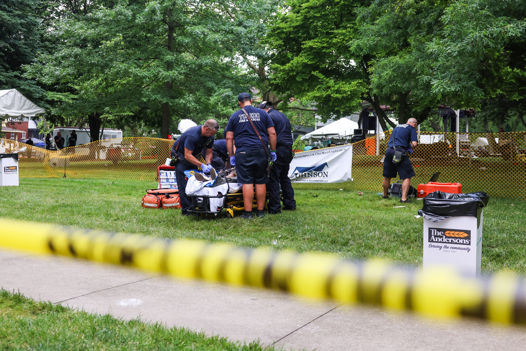 First responders help a woman who was injured the mass shooting that left 12 people injured at the Old West End Festival at the Agnes Reynolds Jackson Arboretum in Toledo, Ohio on Saturday, June 6, 2026. (Rebecca Benson/The Blade via AP)