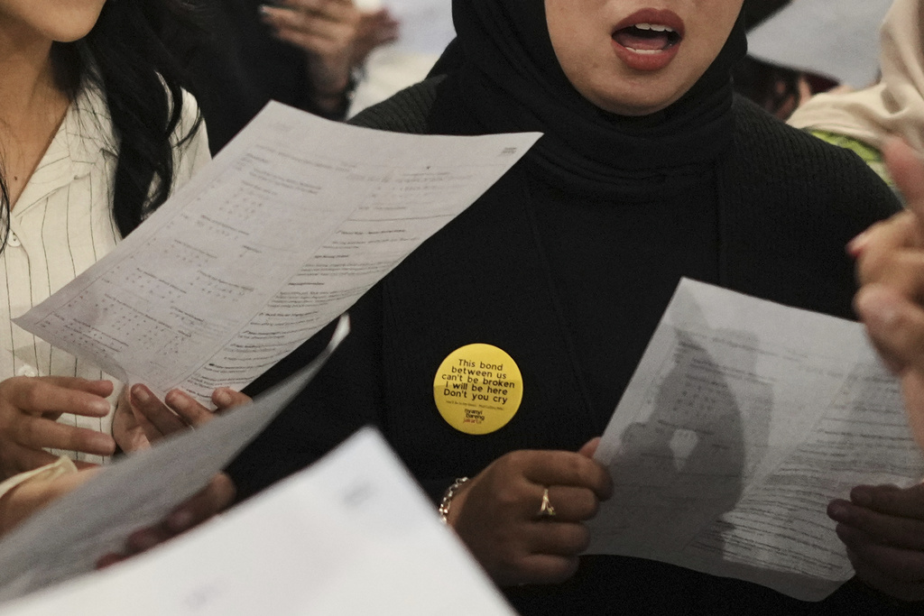 A participant wears a pin with a verse from "You'll Be In My Heart" by Phil Collins during a gathering of "Nyanyi Bareng Jakarta" or "Singing Together Jakarta" community in Jakarta, Indonesia, Saturday, July 19, 2025. (AP Photo/Dita Alangkara)