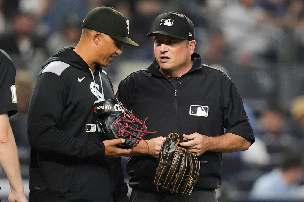 Chicago White Sox manager Will Venable, left, talks to umpire Dan Bellino who's holding a glove taken from pitcher Tyler Gilbert during the fifth inning of a baseball game against the New York Yankees Thursday, Sept. 25, 2025, in New York. (AP Photo/Frank Franklin II)