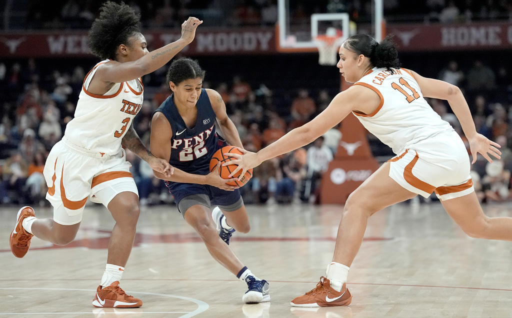 Texas guard Rori Harmon and Texas forward Justice Carlton defend against Penn guard Mataya Gayle during the first half of an NCAA college basketball game in Austin, Texas, Sunday, Nov. 30, 2025. (AP Photo/Rodolfo Gonzalez)