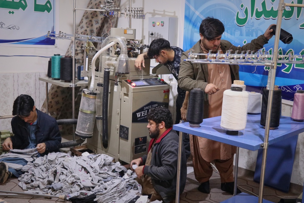 Local businessman Mohammad Amiri, 35, right, sorts out spools of thread for making socks as he works with his staff, all people with disabilities, in his sock production workshop in the western Afghan city of Herat, Afghanistan, Monday, Dec. 8, 2025.(AP Photo/Omid Haqjoo)