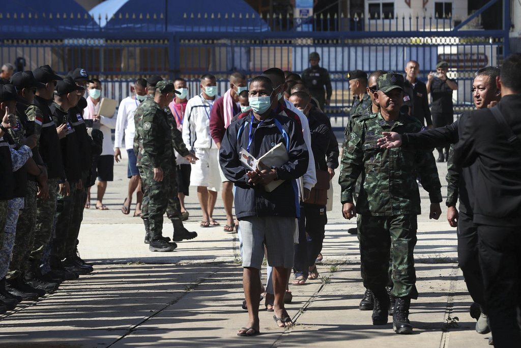 In this photo released by Agence Kampuchea Press (AKP), Cambodian soldiers, center, arrive after being captured and held by the Thai army, at Prum border gate, in Pailin province, Cambodia, Wednesday, Dec. 31, 2025. (AKP via AP)