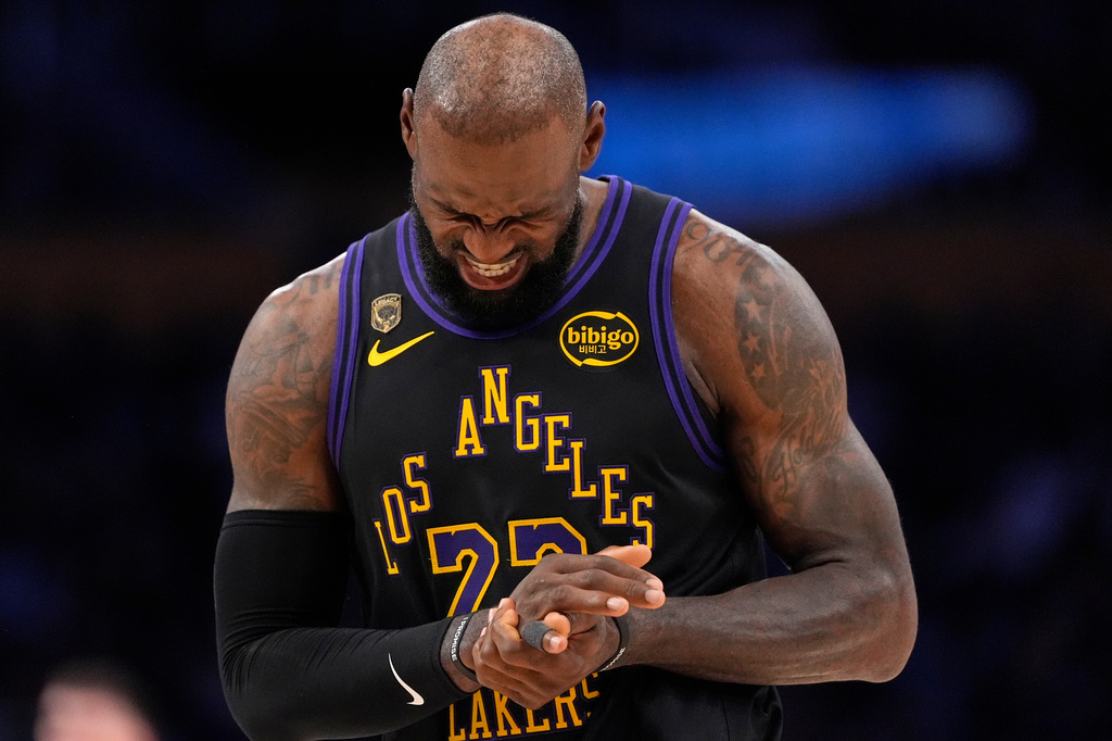 Los Angeles Lakers forward LeBron James grimaces as he holds his finger during the first half in Game 2 of a first-round NBA playoffs basketball series against the Houston Rockets, Tuesday, April 21, 2026, in Los Angeles. (AP Photo/Mark J. Terrill)