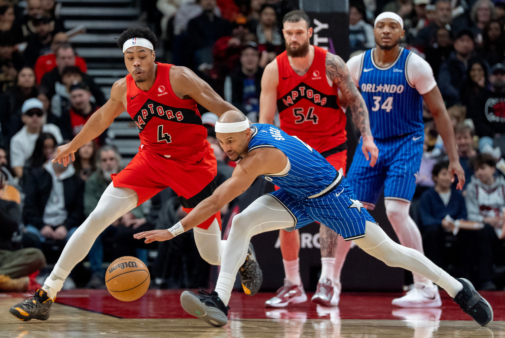 Toronto Raptors forward Scottie Barnes (4) and Orlando Magic guard Jalen Suggs (front) chase down a loose ball during first half NBA action in Toronto on Sunday, March 29, 2026. (Frank Gunn/The Canadian Press via AP)