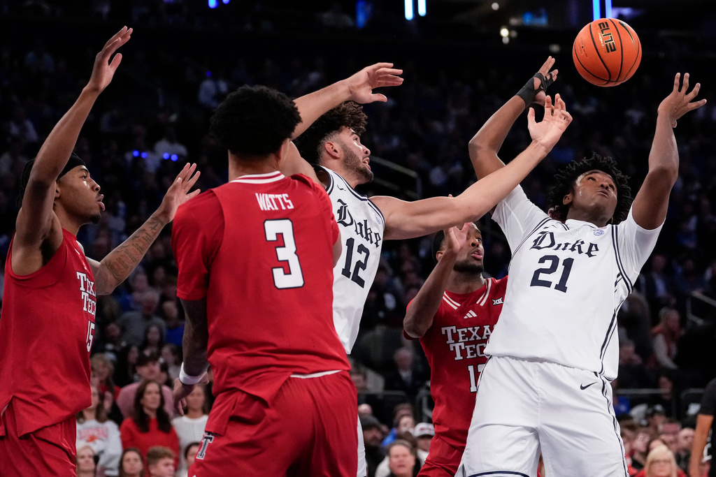 Duke center Patrick Ngongba (21) fights for control of the ball with Duke forward Cameron Boozer (12) during the first half of an NCAA college basketball game against Texas Tech, Saturday, Dec. 20, 2025, in New York. (AP Photo/Yuki Iwamura)