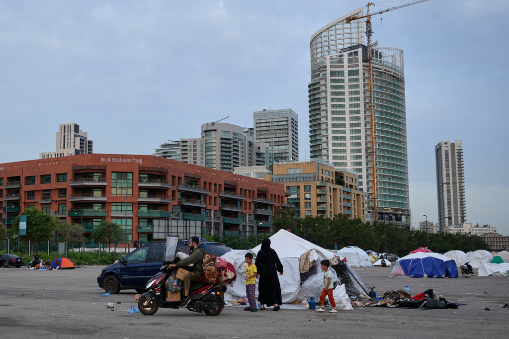 A displaced man with his family's belongings on a scooter prepares to return home following a ceasefire between Hezbollah and Israel in Beirut, Lebanon, Friday, April 17, 2026. (AP Photo/Hussein Malla)