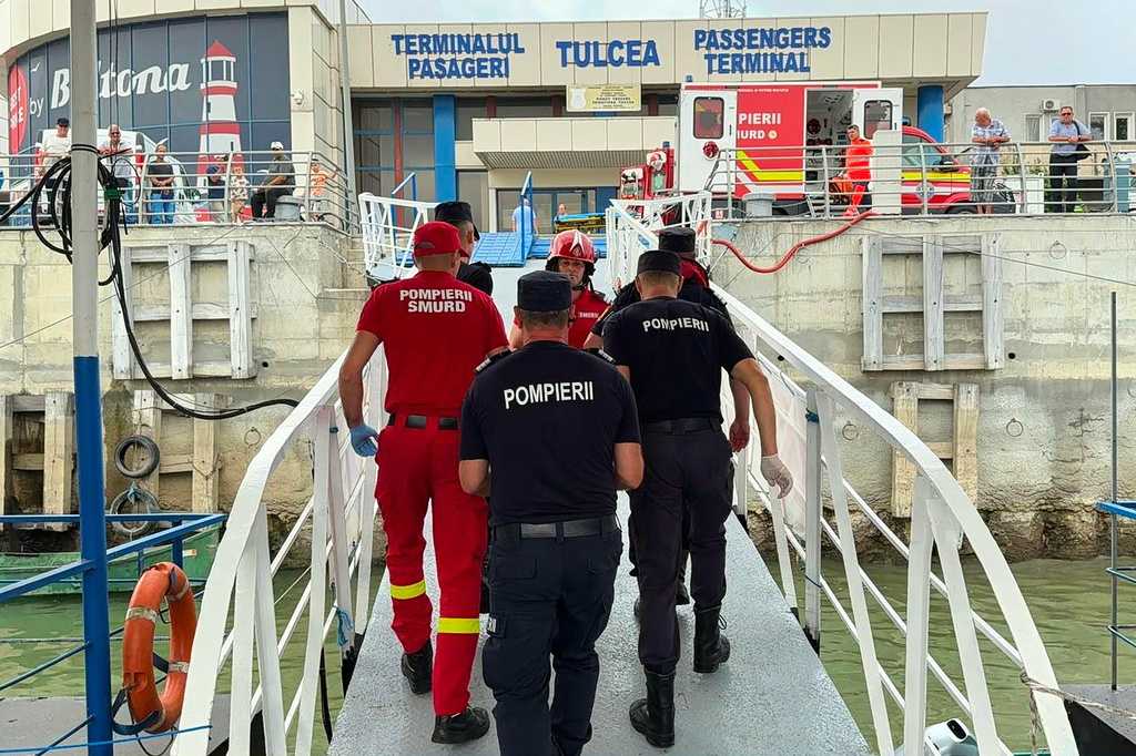 An image released by ISU Tulcea, Romanian Inspectorate for Emergency Situations, shows rescuers and paramedics walking at a docking area in Tulcea, Romania, Tuesday, July 21, 2026, after an LPG tanker ship sailing across the Black Sea toward a Ukrainian port caught fire off the coast of Romania last night, an incident Romania's president said was "most likely" related to Russia's war in Ukraine. (ISU Tulcea via AP)