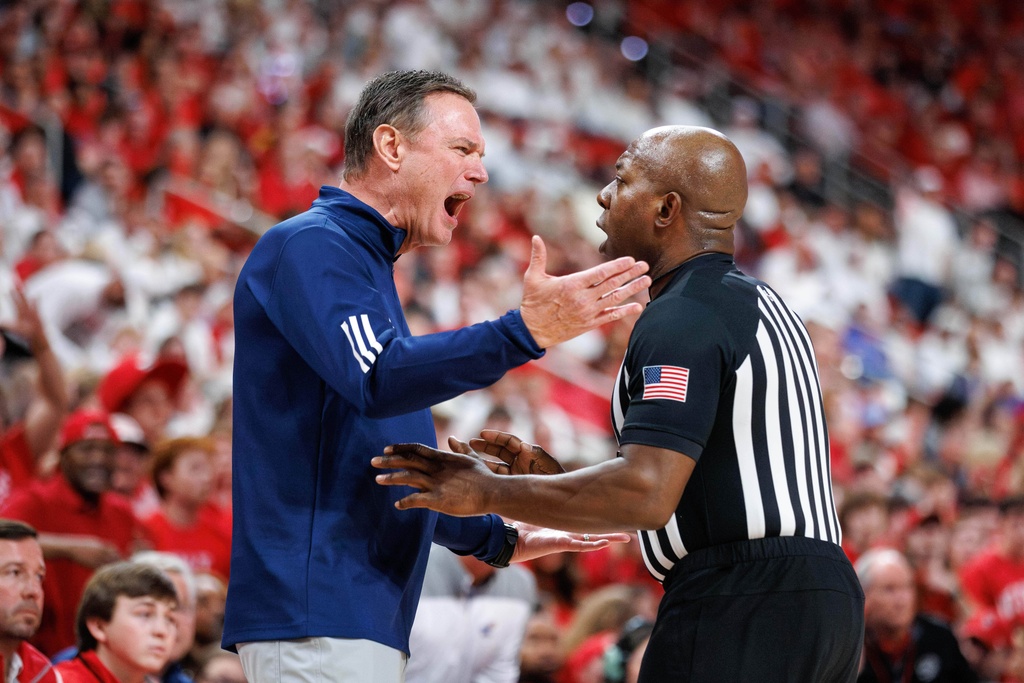 Kansas head coach Bill Self, left, argues with official Clarenfe Armstrong during the first half of an NCAA college basketball game against North Carolina State in Raleigh, N.C., Saturday, Dec. 13, 2025. (AP Photo/Ben McKeown)