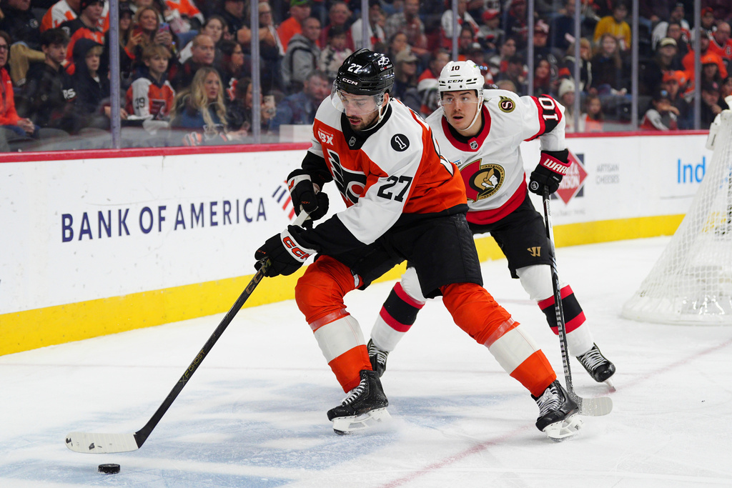 Philadelphia Flyers' Noah Cates, left, skates the puck past Ottawa Senators' Jordan Spence during the second period of an NHL hockey game, Saturday, Nov. 8, 2025, in Philadelphia. (AP Photo/Derik Hamilton)
