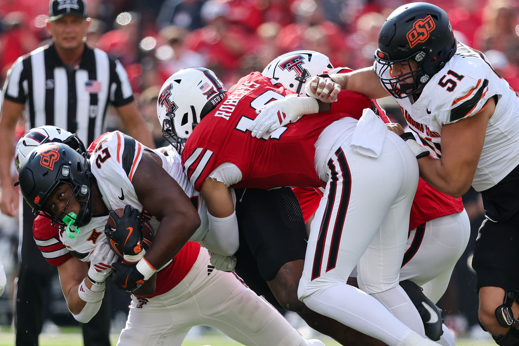 FILE - Oklahoma State running back Trent Howland, front left, is tackled by Texas Tech linebacker Jacob Rodriguez (10) during the first half of an NCAA college football game, Saturday, Oct. 25, 2025, in Lubbock, Texas. (AP Photo/Chase Seabolt, File)