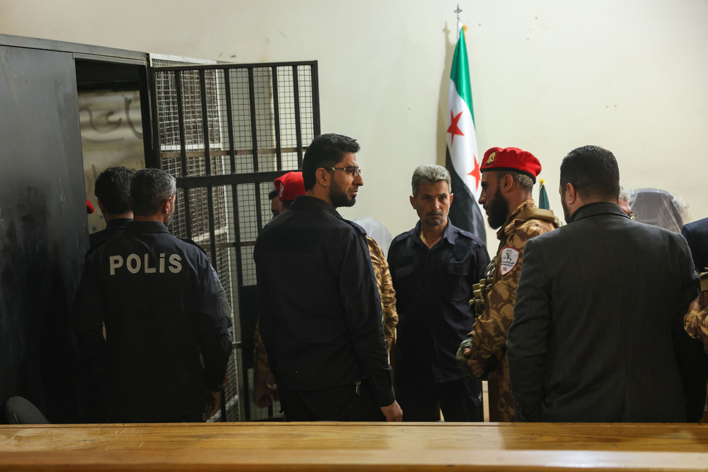 Security guards stand by a holding cell during Syria's first public trial related to deadly clashes in March along the country's coastal provinces, at the Palace of Justice in Aleppo, Syria, Tuesday, Nov. 18, 2025. (AP Photo/Ghaith Alsayed)