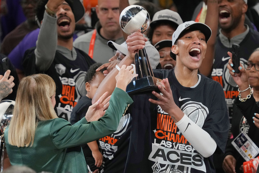 FILE - Las Vegas Aces center A'ja Wilson, center right, holds up her MVP trophy after Game 4 of the WNBA basketball finals against the Phoenix Mercury, Friday, Oct. 10, 2025, in Phoenix. (AP Photo/Rick Scuteri, File)