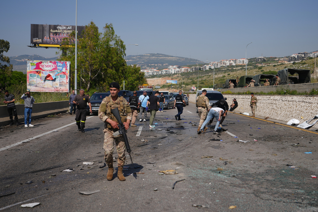 ecurity forces and residents inspect and clear debris scattered across a road at the scene of an Israeli airstrike that hit a car in the coastal town of Saadiyat, south of Beirut, Lebanon, Saturday, May 9, 2026. (AP Photo/Hassan Ammar)