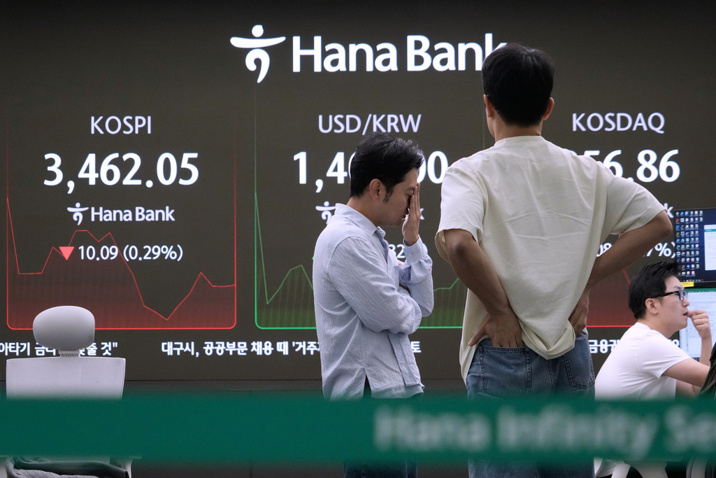 Currency traders work near a screen showing the Korea Composite Stock Price Index (KOSPI), left, at the foreign exchange dealing room of the Hana Bank headquarters in Seoul, South Korea, Thursday, Sept. 25, 2025. (AP Photo/Ahn Young-joon)