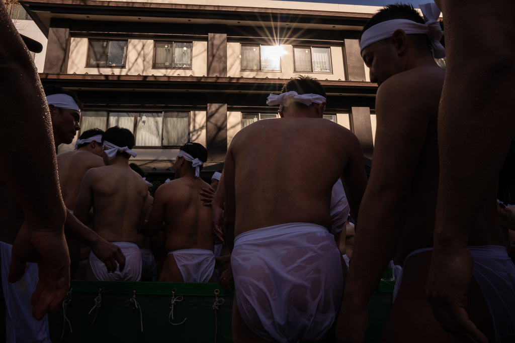 Participants bathe in ice-cold water to purify their souls and pray for good health during a New Year's ritual at Teppozu Inari Shrine in Tokyo, Sunday, Jan. 11, 2026. (AP Photo/Louise Delmotte)