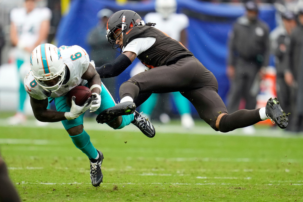 Miami Dolphins wide receiver Malik Washington (6) is hit by Cleveland Browns safety Rayshawn Jenkins in the second half of an NFL football game in Cleveland, Sunday, Oct. 19, 2025. (AP Photo/Sue Ogrocki)