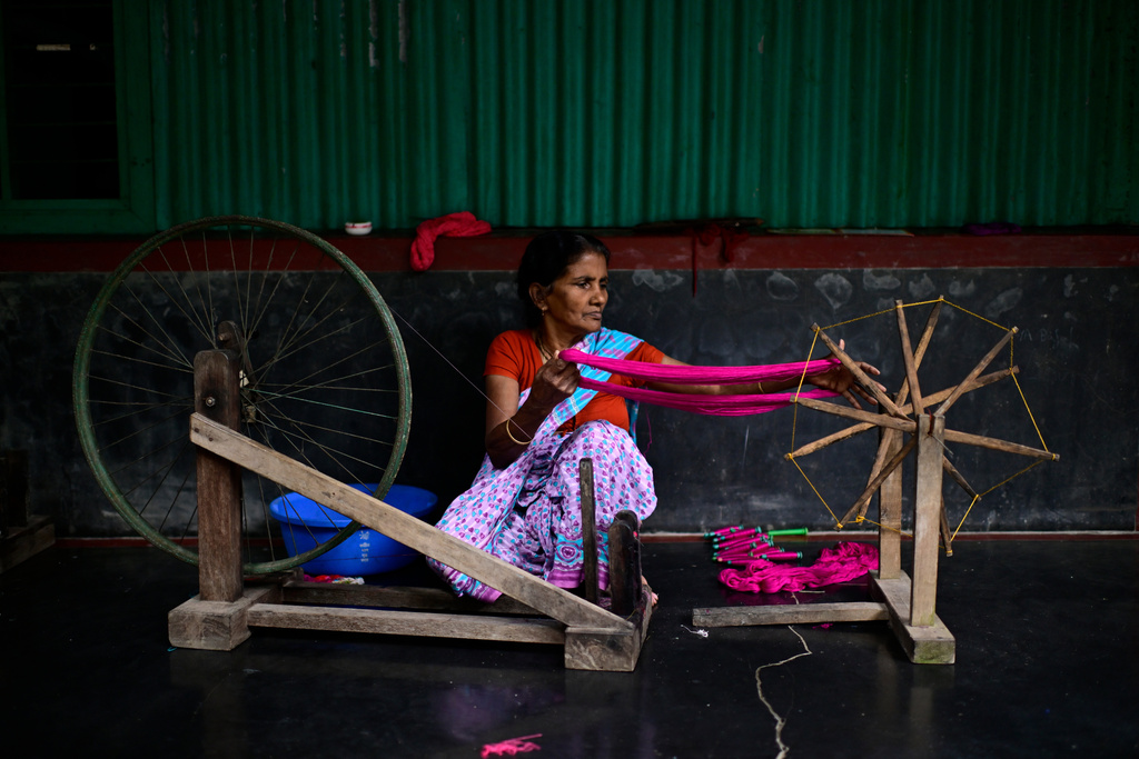 A weaver uses a spinning wheel to make yarn to be used in the making of Tangail sarees at a workshop in Tangail District, Bangladesh, Nov. 5, 2025. (AP Photo/Mahmud Hossain Opu)